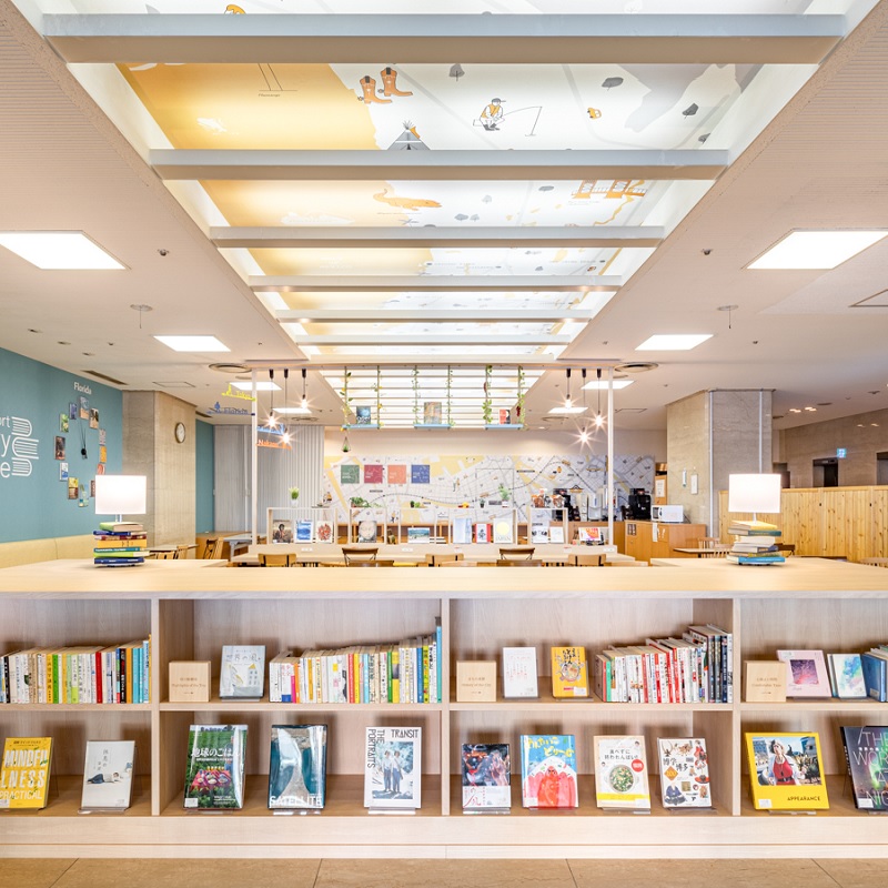 Comfort Library Cafe breakfast area with bookshelves, illustration ceiling panels, and buffet counters