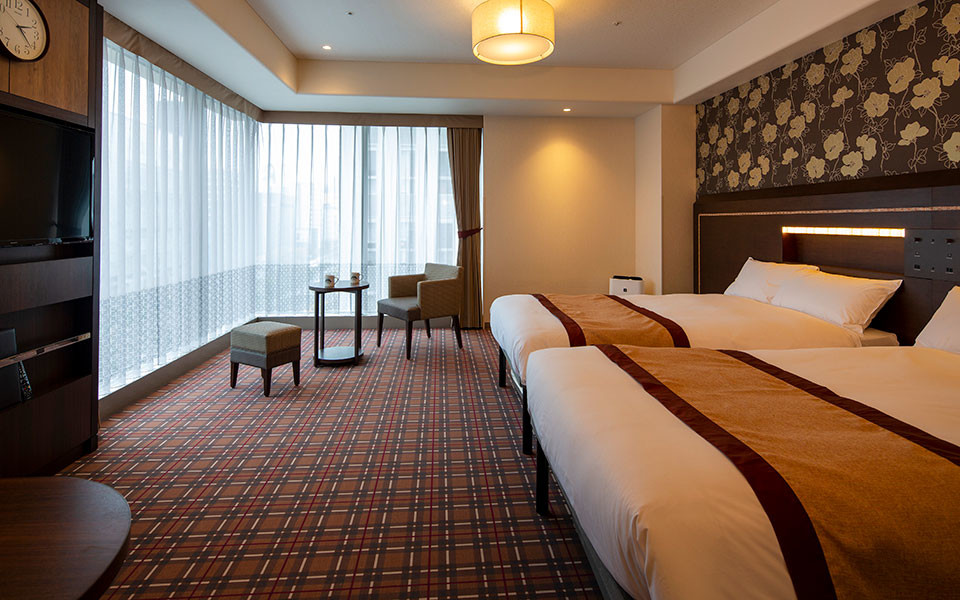 Hotel Monterey Fukuoka upper-floor twin room with floor-to-ceiling windows framing city views