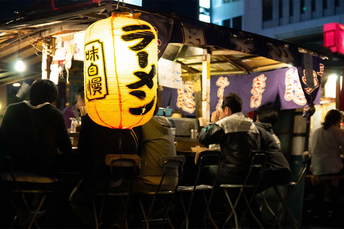 Nakasu yatai open-air stalls at night with glowing red lanterns and ramen signs