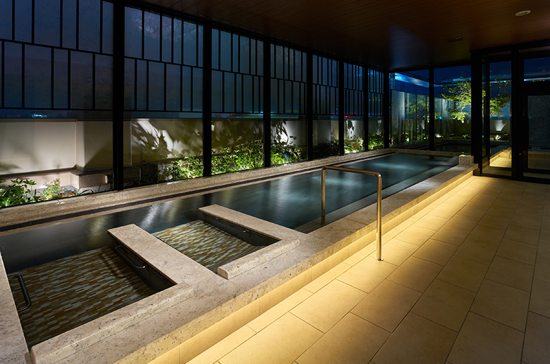 Women's section of the 13th-floor public bath at Mitsui Garden Hotel Fukuoka Gion with evening lighting