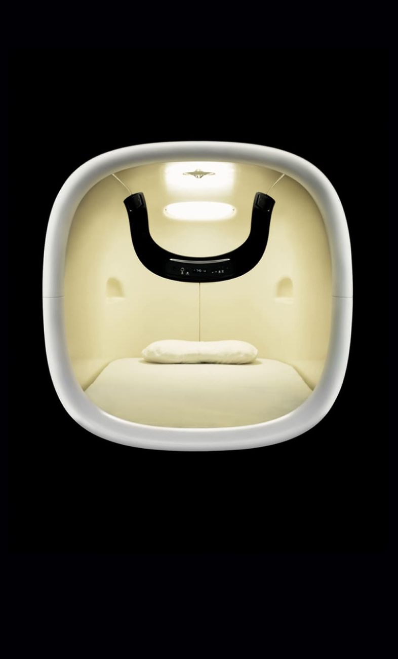 9h nine hours capsule pod interior — rounded FRP shell with amber lighting, custom pillow and mattress