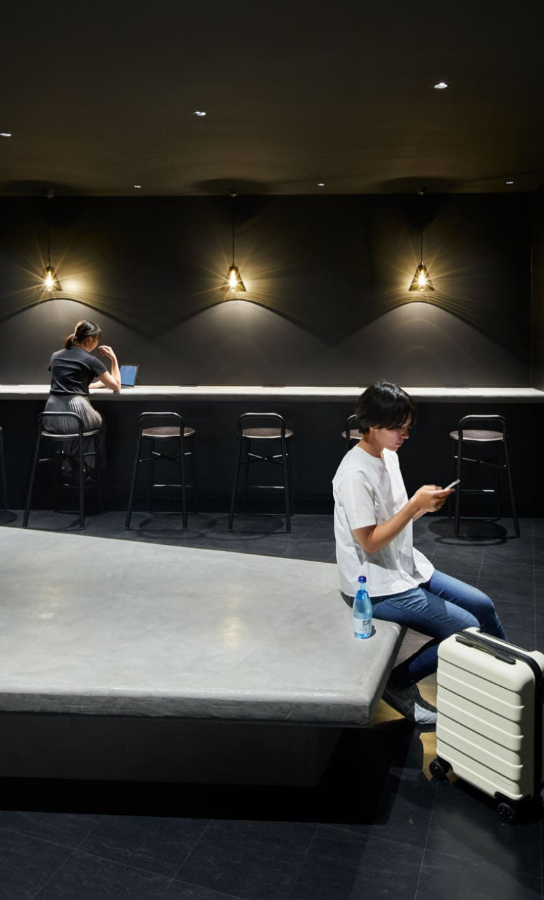 9h nine hours lounge area — concrete bench seating with pendant lights and counter bar seating