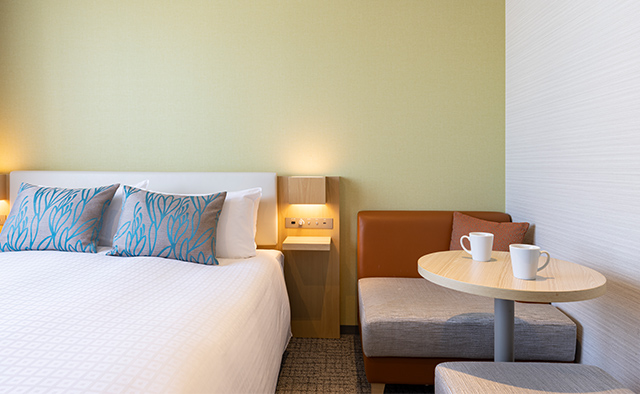 Tokyu Stay Hakata double room with warm lighting and lounge chairs