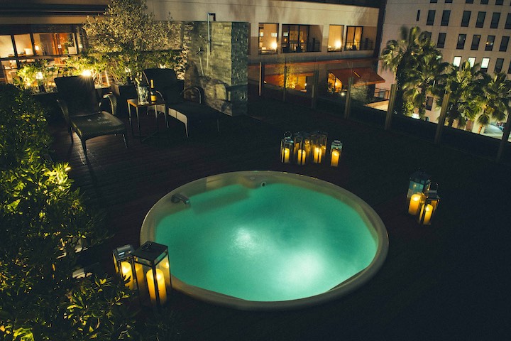 WITH THE STYLE FUKUOKA courtyard jacuzzi pool at night with candle lanterns